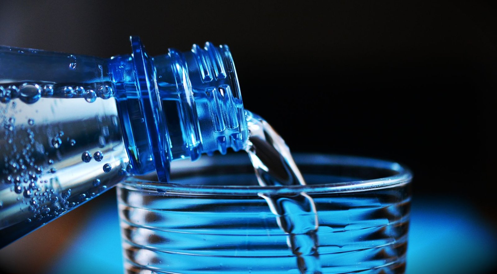 Agua sirviéndose en un vaso: la hidratación ayuda a ablandar las heces y aliviar las hemorroides